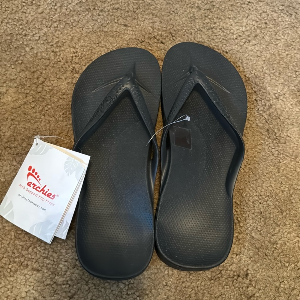 Archie’s black flip flops